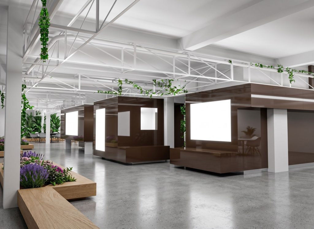 Interior moderno de oficina con áreas de trabajo y vegetación, diseñado para reformas y construcciones de Apro CM.