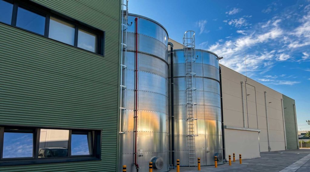 Tanques de almacenamiento de acero inoxidable en un sitio de construcción, relacionados con reformas y construcciones.