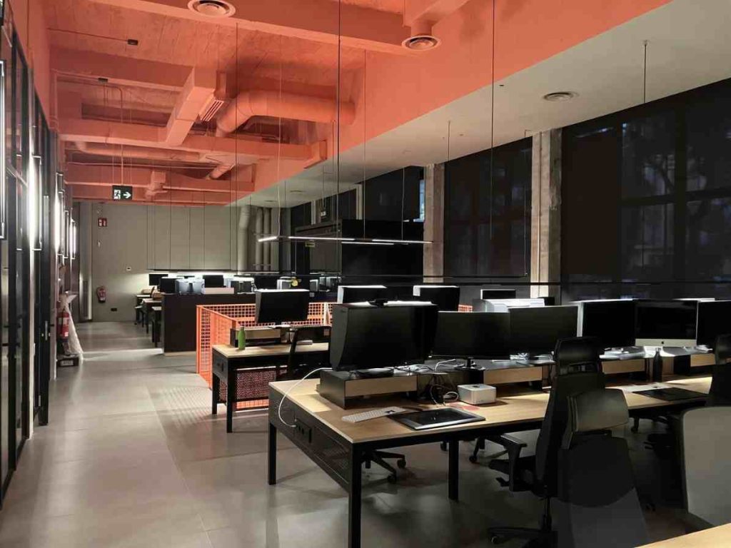 Oficina moderna con escritorios, computadoras y un diseño minimalista, ideal para reformas y construcciones.